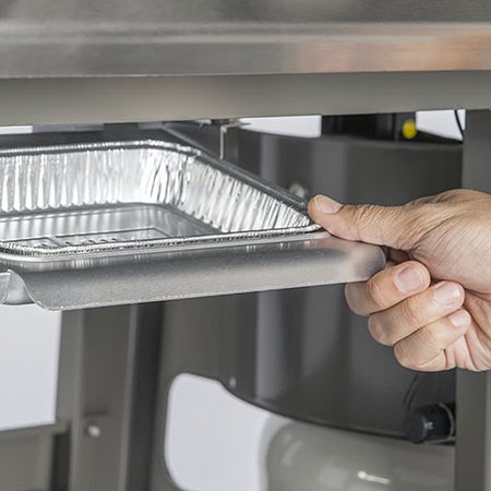 Weber drip tray with a hand pulling the tray out